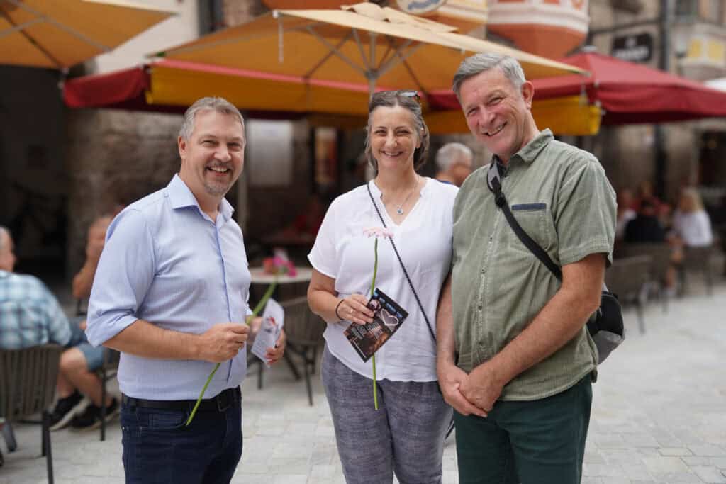 Geschäftsführer Peter Margreiter überreicht Kunden Geburtagsblume.